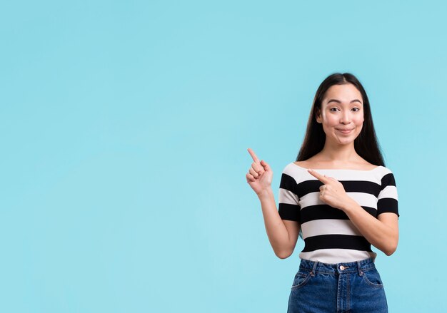 Mujer sonriente apuntando con espacio de copia