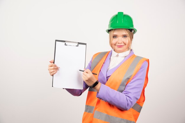 Mujer sonriente arquitecto en casco con tableta en blanco.