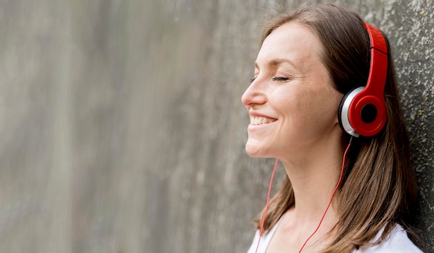 Foto gratuita mujer sonriente con auriculares