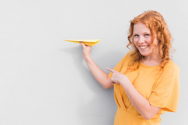 Mujer sonriente y avión de papel