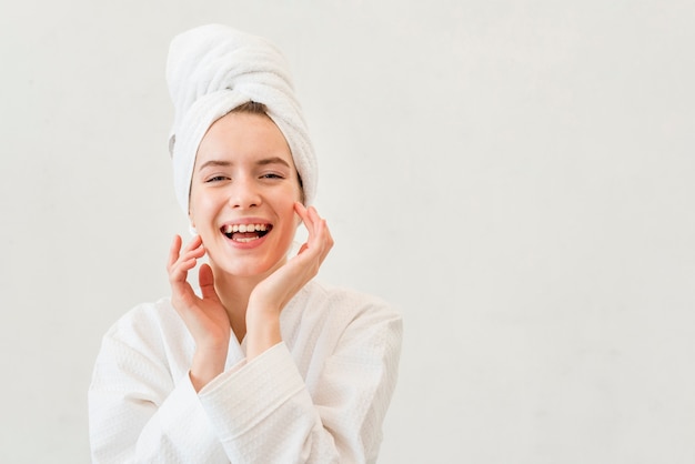 Mujer sonriente en bata de baño con espacio de copia