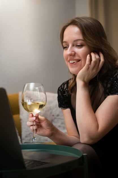 Mujer sonriente con bebida en casa tiro medio