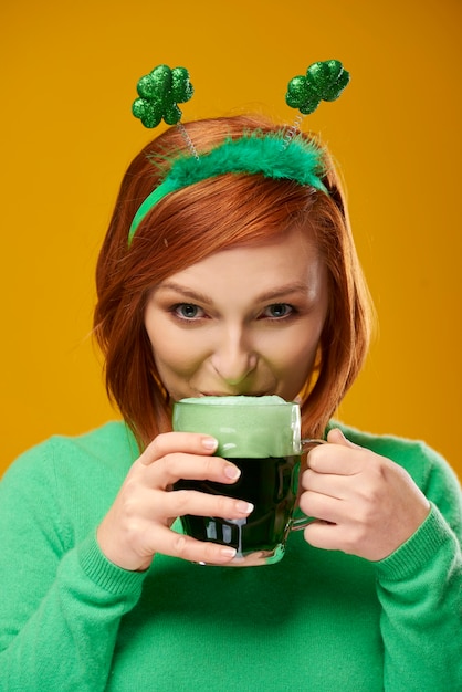 Mujer sonriente bebiendo cerveza