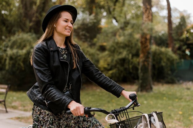 Mujer sonriente y bicicleta en el parque
