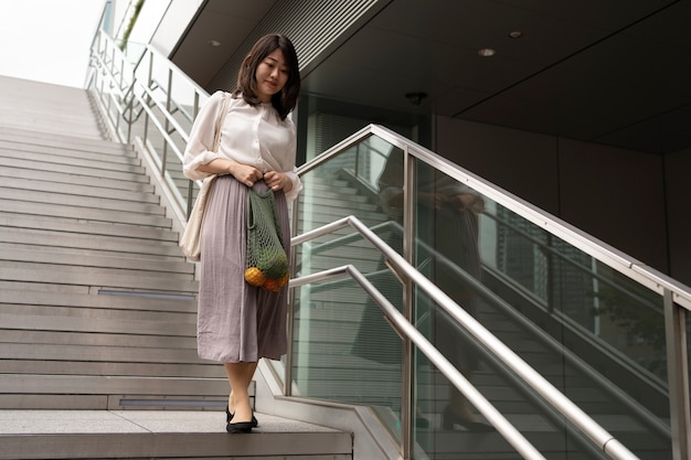 Mujer sonriente con bolsa de tela tiro completo