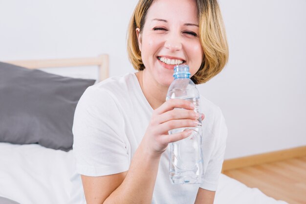 Mujer sonriente con botella de agua