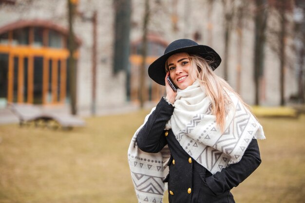 Mujer sonriente con bufanda y sombrero