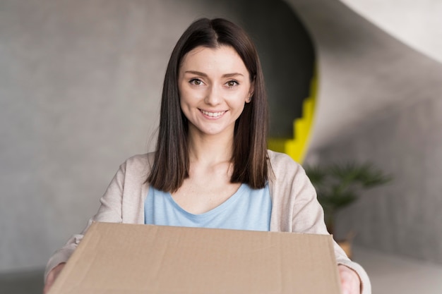 Foto gratuita mujer sonriente con caja de cartón