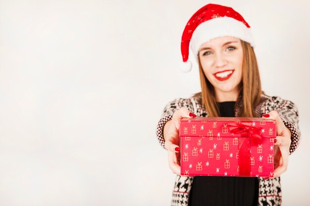 Mujer sonriente con caja de regalos en las manos