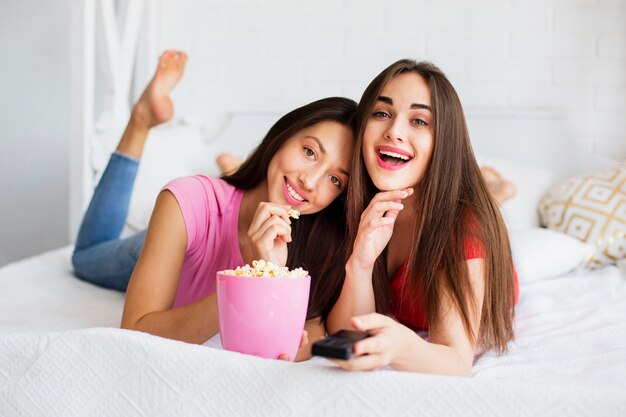 Mujer sonriente en la cama mirando a la cámara