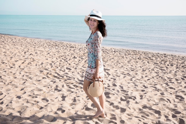 Mujer sonriente caminando en la playa