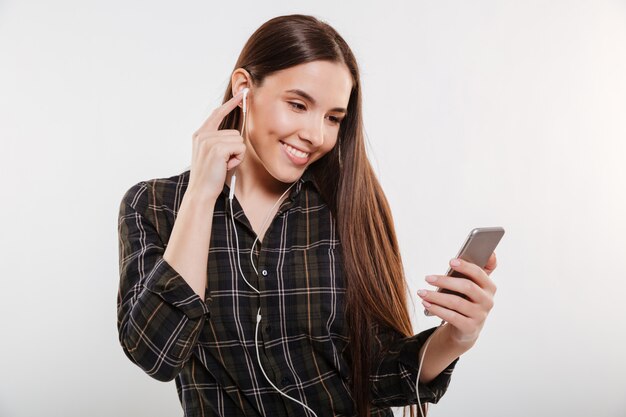 Mujer sonriente en camisa escuchando música