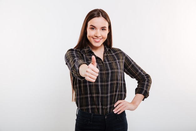 Mujer sonriente en camisa mostrando el pulgar hacia arriba