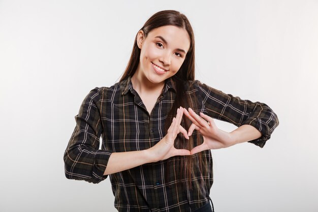 Mujer sonriente en camisa mostrando signo de corazón