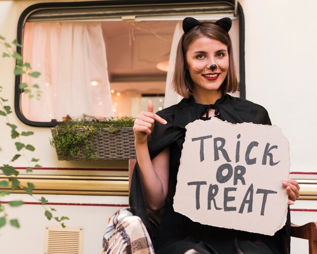 Mujer sonriente con cartel de halloween