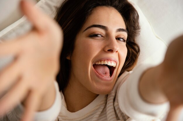 Mujer sonriente en casa en la cama