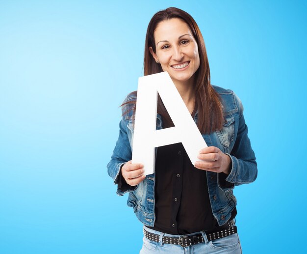 Mujer sonriente con chaqueta vaquera con la letra "a"