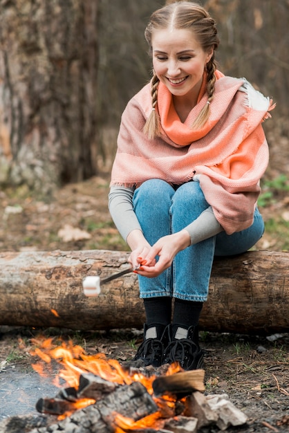 Mujer sonriente cocinando malvavisco