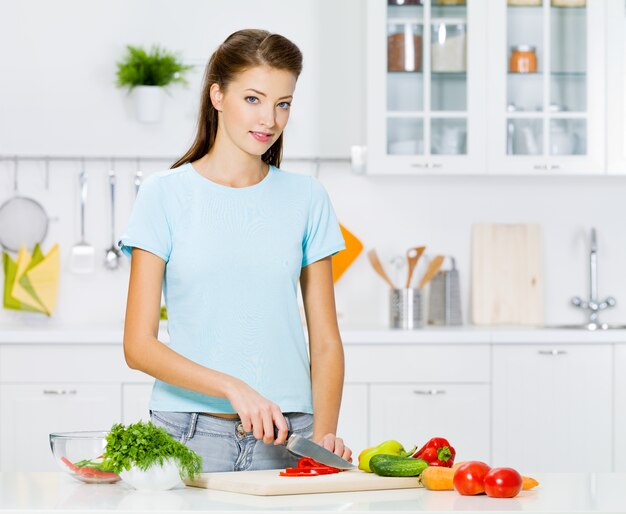 Mujer sonriente cocinar alimentos saludables en la cocina