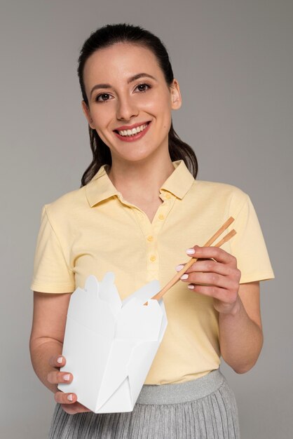 Mujer sonriente comiendo de caja de dibujos animados