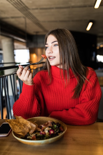 Foto gratuita mujer sonriente comiendo ensalada fresca en el restaurante