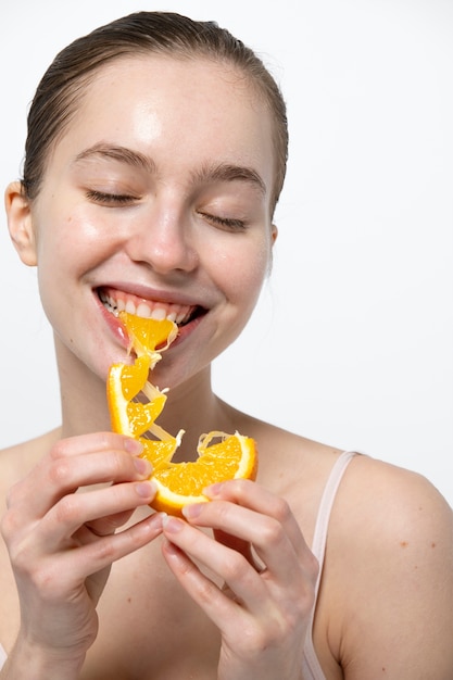 Mujer sonriente comiendo vista frontal naranja