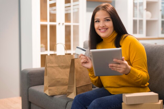 Mujer sonriente comprobando la tableta para una nueva compra