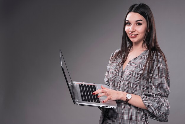 Mujer sonriente con la computadora portátil