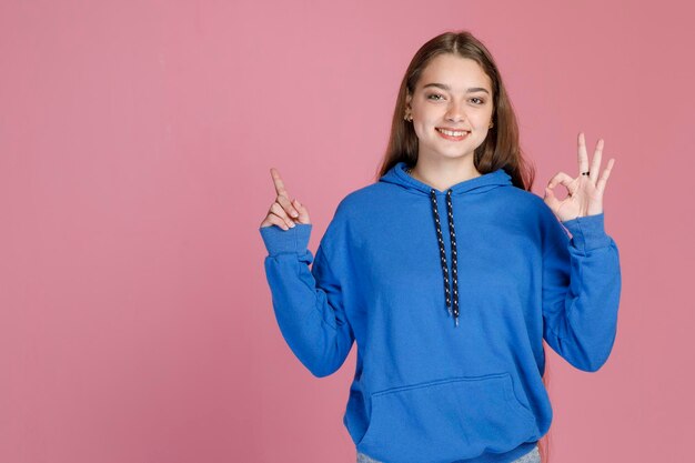 Mujer sonriente confiada que usa ropa informal que muestra el número uno y cero con los dedos mientras gesticula