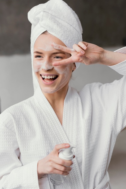 Mujer sonriente con una crema facial blanca