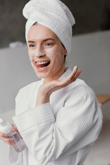Mujer sonriente con una crema facial blanca
