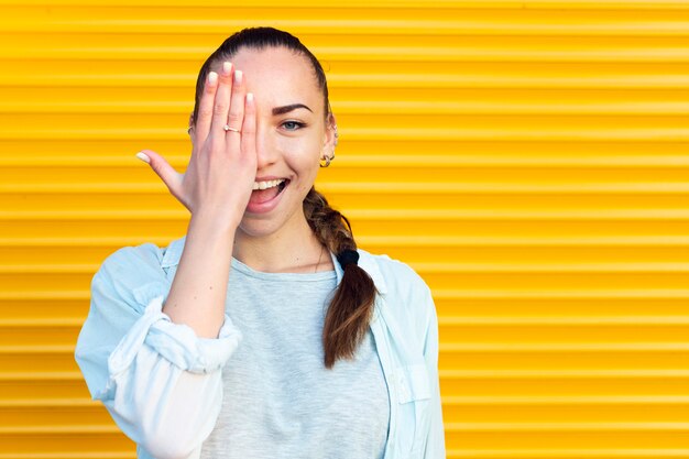 Mujer sonriente cubriendo un ojo