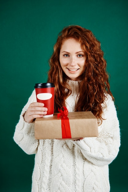Foto gratuita mujer sonriente dando regalos y café