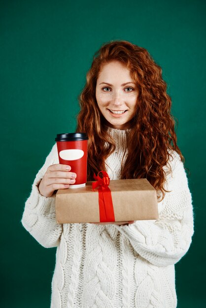 Mujer sonriente dando regalos y café