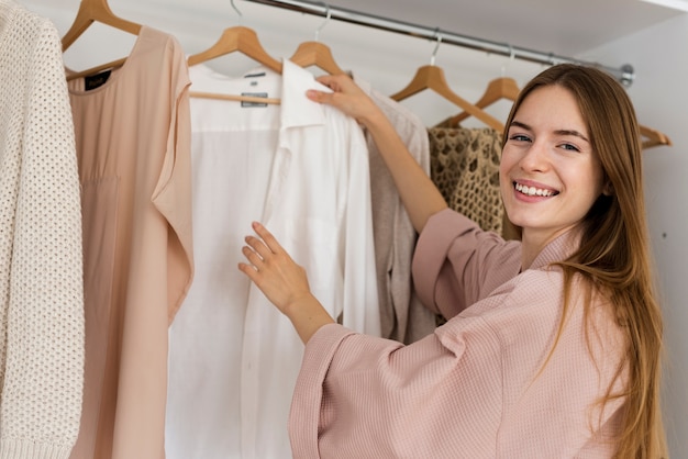 Mujer sonriente decidiendo qué ponerse