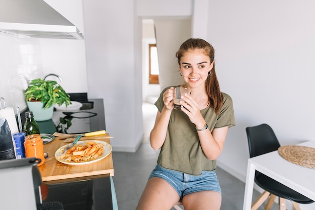 Mujer sonriente desayunando en la cocina