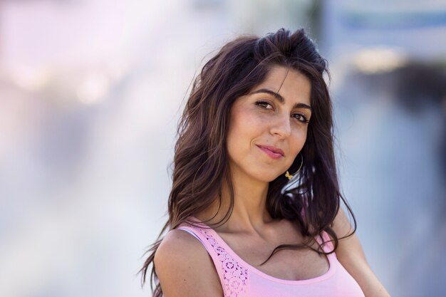 Mujer sonriente en un día soleado con fondo borroso