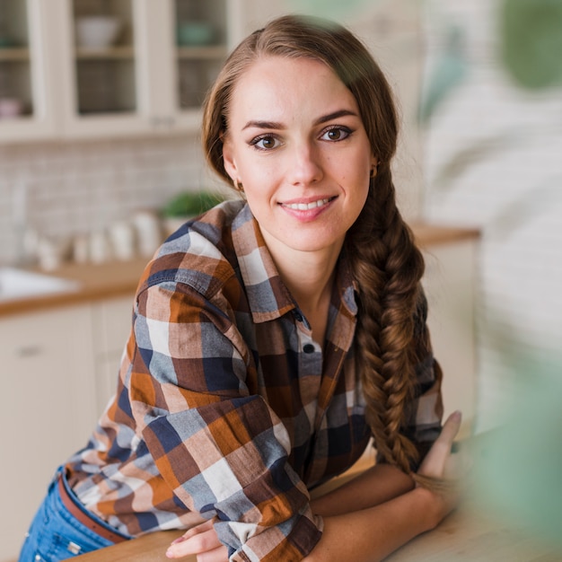 Mujer sonriente con dientes mirando a cámara en la cocina