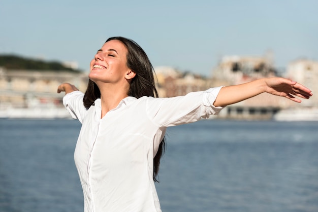 Mujer sonriente disfrutando de la brisa de la playa