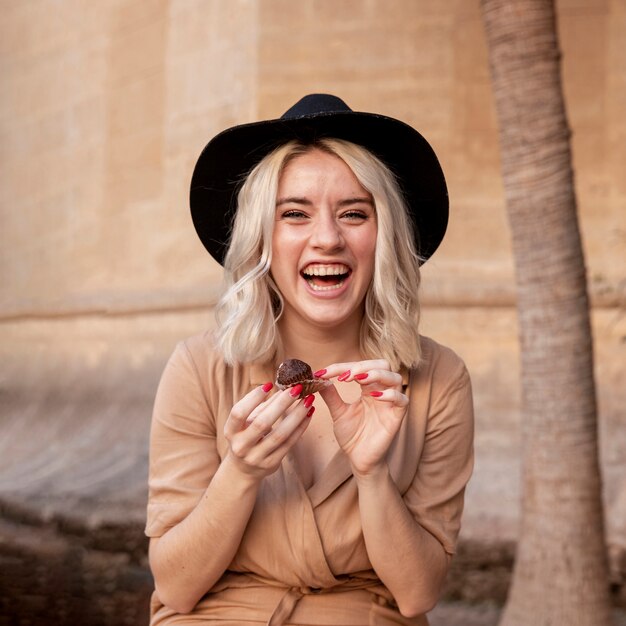 Mujer sonriente disfrutando de un cupcake