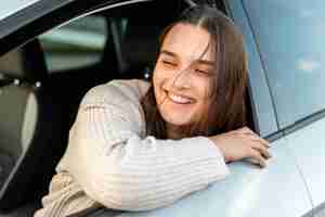 Foto gratuita mujer sonriente disfrutando de un viaje por carretera en su coche