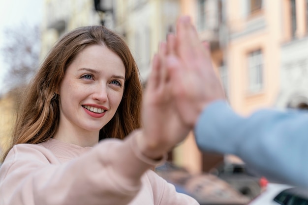 Mujer sonriente divirtiéndose con amigos en la ciudad