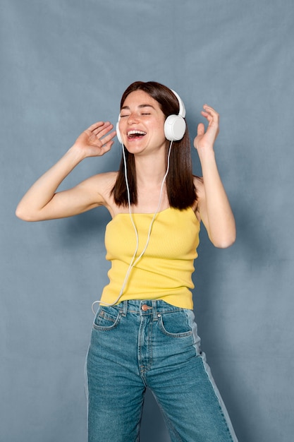 Foto gratuita mujer sonriente divirtiéndose con auriculares