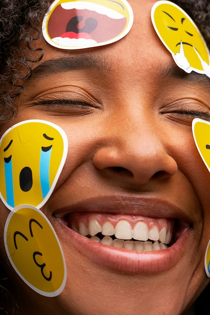 Mujer sonriente con emojis en la vista frontal de la cara