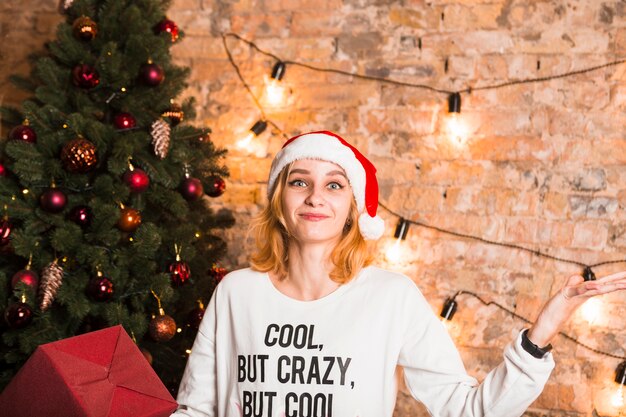 Mujer sonriente enfrente de árbol de navidad