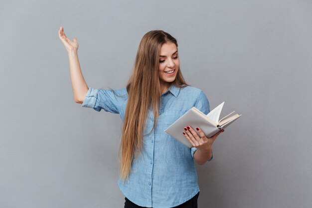 Mujer sonriente ensaya con libro en mano