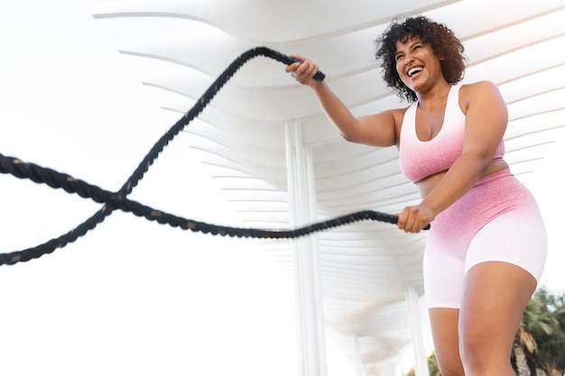 Mujer sonriente entrenando ángulo bajo