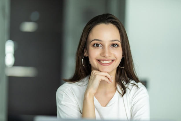 Mujer sonriente escribiendo en su computadora portátil