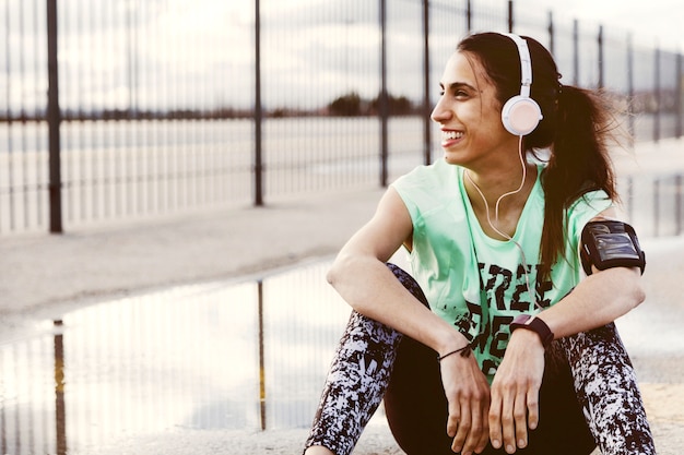 Mujer sonriente escuchando música en auriculares