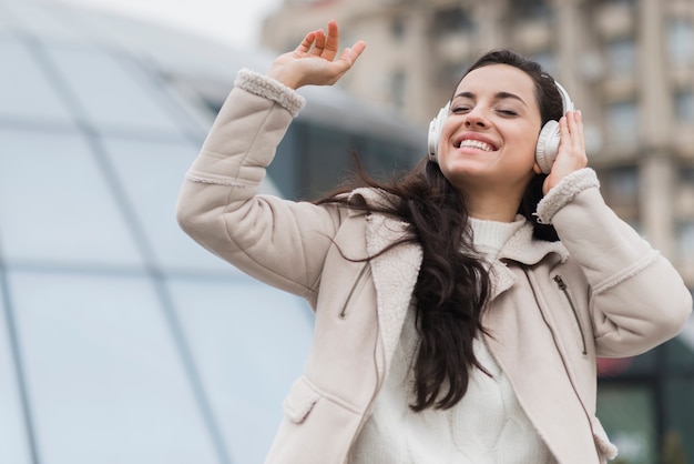 Mujer sonriente escuchando música con auriculares